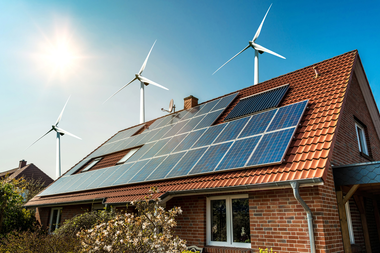 Solar panel on a roof and wind turbines around