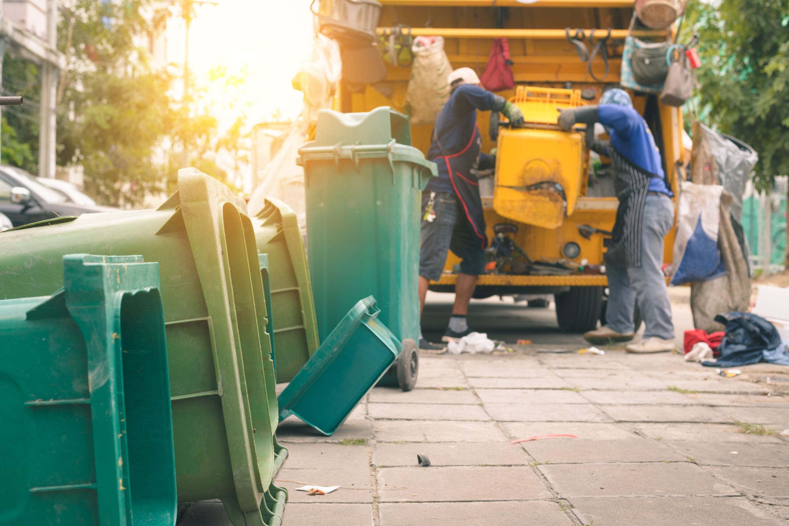 Garbage collector on the garbage truck.Sweeper or Worker are loading waste into the garbage truck carrier.